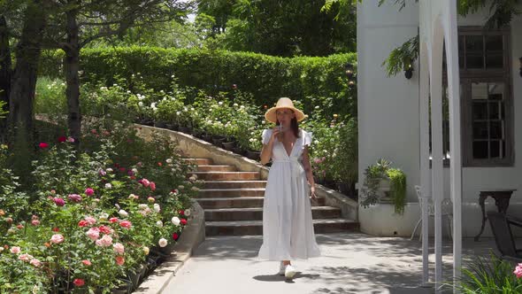 A static shot of a beautiful young woman walking with a juice in her hand, happy enjoy around outdoo