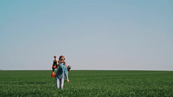 Kid with Jet Pack Outdoor Child Playing in Green Spring Field