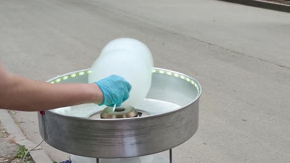 The Process of Making Cotton Candy in the Form of an Animal's Head By a Human Hand in Gloves