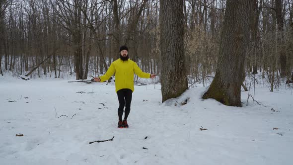 Bearded Fit Man in Yellow Coat Skipping with Jumping Rope in Winter Forest