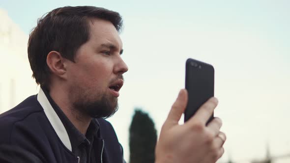 Young Businessman Talking To Business Partner on Phone Outdoors in the Daytime