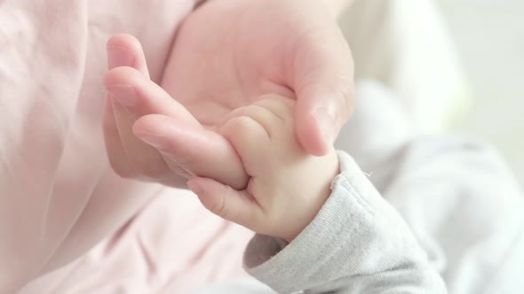 Newborn Baby Hand Holding Mother Mom Touching Baby Tiny Hand to Make Him Feeling Her Love Warm and
