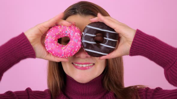 Woman Looking at Camera Through Donuts