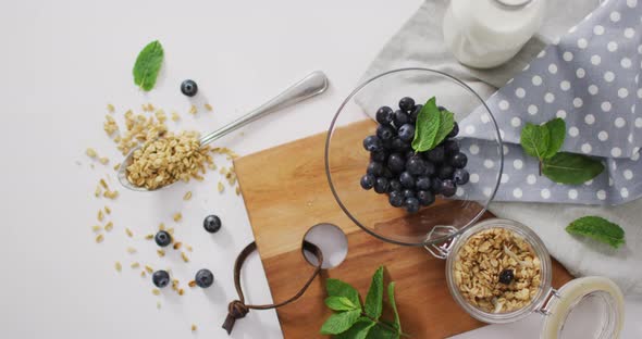 Video of cereals and fruit in ceramic bowl on white kitchen worktop