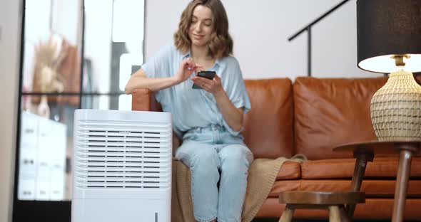 Woman with Air Purifier or Conditioner at Home