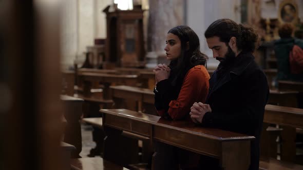 faith, prayer, hope. Young married couple praying in church