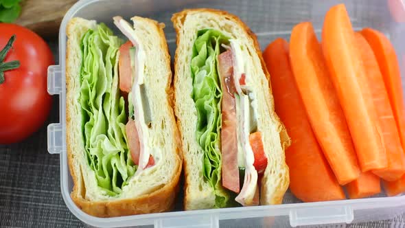 Fresh made sandwiches with carrot sticks in the lunch box, ready to eat, dolly shot, top view