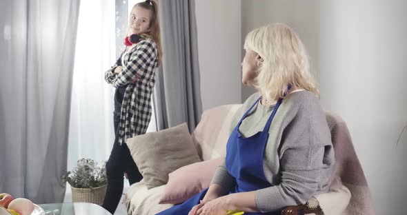 Senior Caucasian Woman Educating Teen Girl Standing with Irritated Facial Expression and Turning