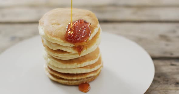 Video of pancakes with maple syrup on white plate seeing from above
