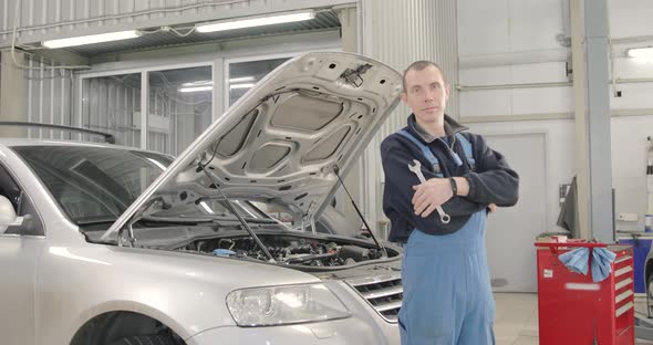 Portrait Of Mechanic. He's Turning In The Camera With Arms Crossed