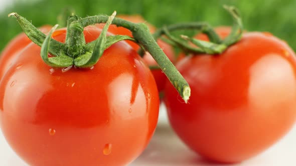 Ripe natural tomatoes close-up. Organic tomato rotating on a green background Macro shot.