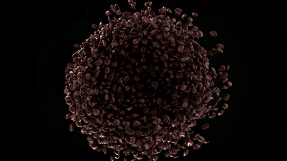 Super Slow Motion Shot of Rotating and Exploding Premium Coffee Beans Isolated on Black at 1000Fps