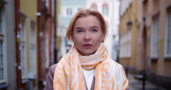 Portrait of a Pretty Girl Standing Among the Buildings