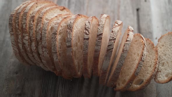 Sliced sourdough bread falling on a table. Slow Motion.