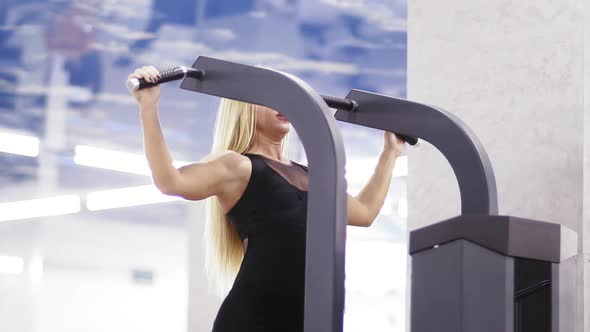 Attractive Sexy Young Blond Girl Doing Pull Ups at the Gym