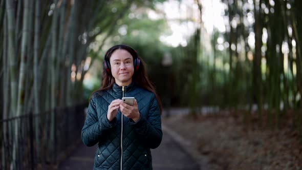 Calm Weekend Walk in Nature Middleaged Woman is Walking and Listening to Player By Headphones