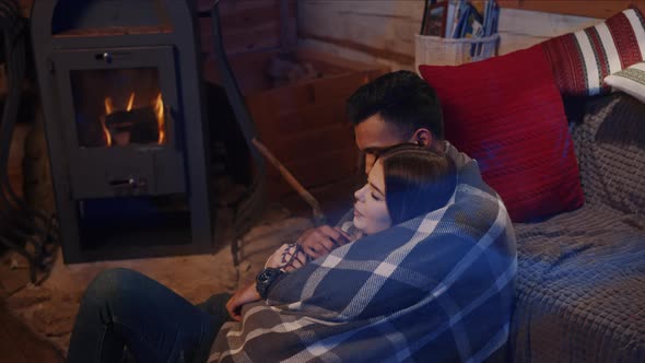 Couple Sitting By the Burning Fireplace in a Cozy House