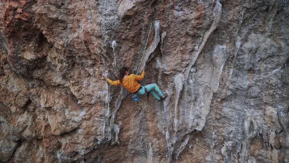 Back View of Strong Skillful Man Rock Climber Climbs Overhanging Tough Route with Rock Tufa Making