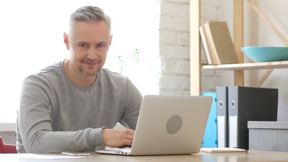 Middle Aged Man Looking  toward Camera at Work