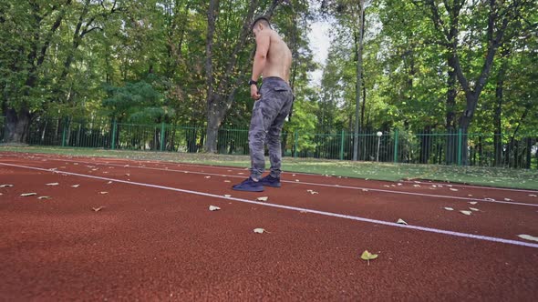 Sportive runner on outdoor athletics track. 