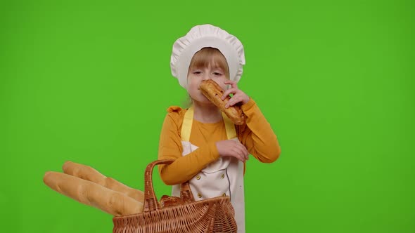 Child Girl Chef Showing Basket with Baguette and Bread Smiling Sniffing Eating Bun with Cream