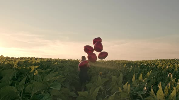 Attractive Woman in Feminine Midi Dress Having Fun with Heart-shaped Balloons on Green Nature