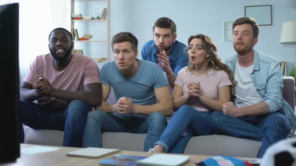 Multiracial Friends Sitting on Couch and Watching Game, Disappointed With Result