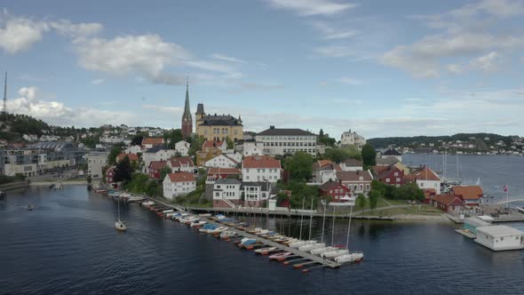 Sailboats Anchored On The Woode Jetty With The Arendal City Under The Bright Blue Sky In Agder Count