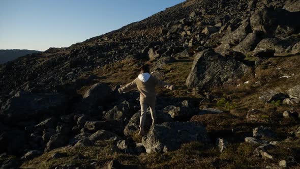 Inspired Girl Dreamily Walks Among the Mountains Surrounded By Stones