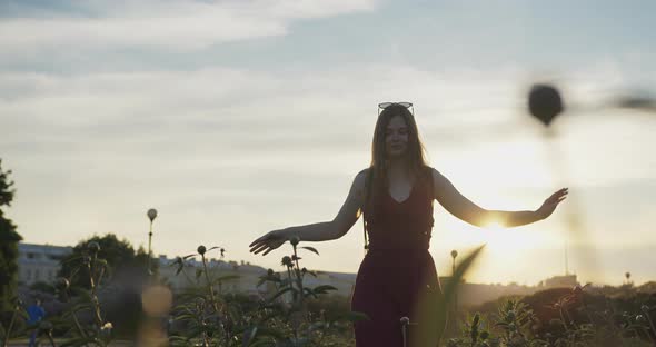 Young Beautiful Girl Dancing in the City Against the Backdrop of the Sunset Sky