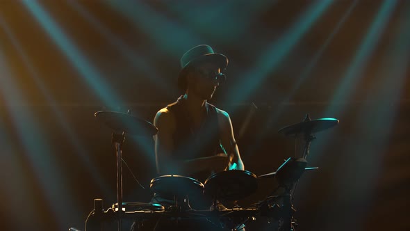 Solo Performance of Drummer in Dark Smoke Studio in Rays of Blue Light