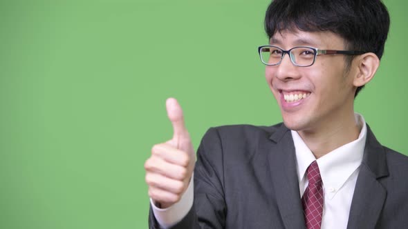 Young Happy Asian Businessman Smiling While Giving Thumbs Up