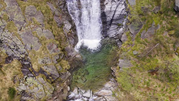 Aerial View of Waterfall Flowing Trough Rocks of Mountain