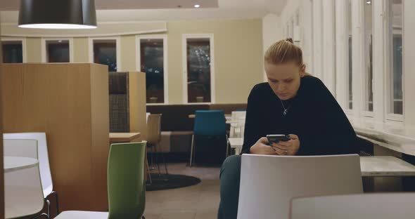 Woman Sitting Alone in Cafe and Using Mobile