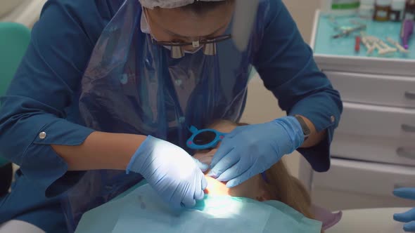 the Doctor Puts Mouth Dilator in the Mouth of a Little Girl's Patient