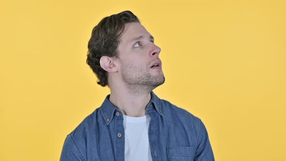 Worried Young Man Feeling Shocked on Yellow Background