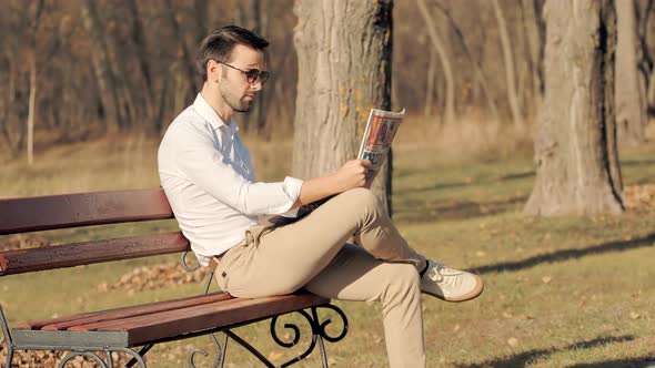 Man Reading Newspaper.Man Sitting On Bench And Reading Newspaper.Man in Sunglasses Taking Rest