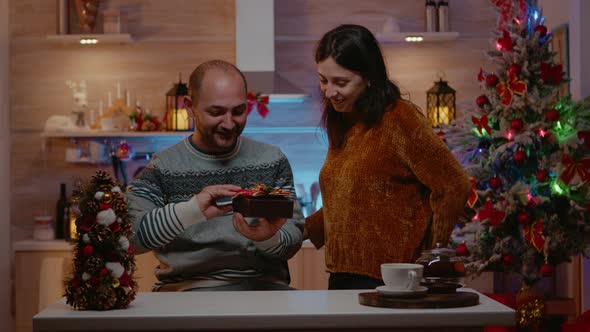 Man Receiving Gift From Woman on Christmas Eve Day