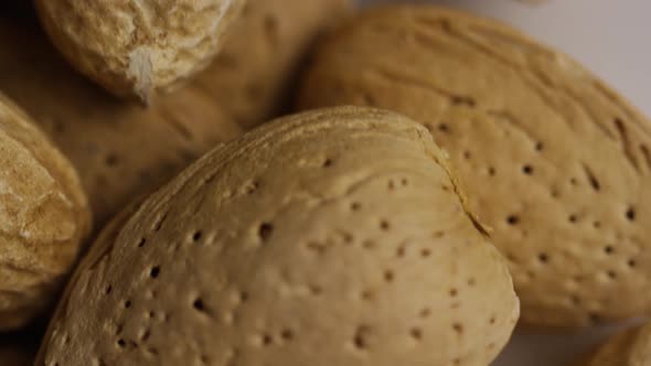 Cinematic, rotating shot of a variety of nuts on a white surface - NUTS MIXED 013