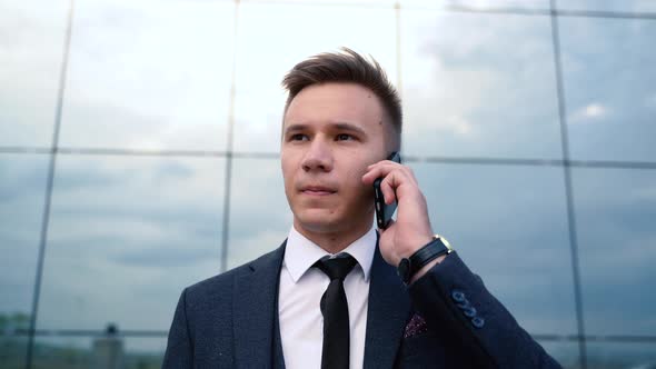 Businessman Nervously Talking on the Phone Talking on Smartphone in City Outdoors