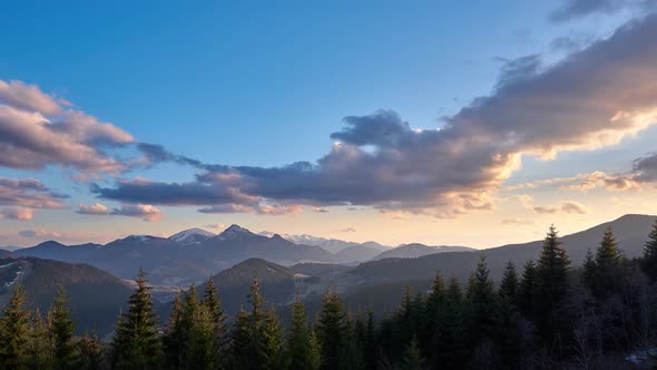 Beautiful mountain landscape at sunset, spring weather, colorful moving clouds in the blue sky