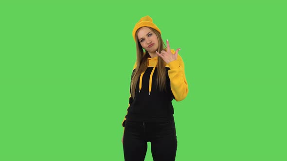 Modern Girl in Yellow Hat Is Making a Rock Gesture and Enjoying Life. Green Screen