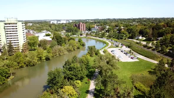 Drone Flying Over a Beautiful River in a Lush City Park.