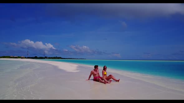 Guy and girl tan on beautiful coast beach time by clear ocean and white sandy background of the Mald