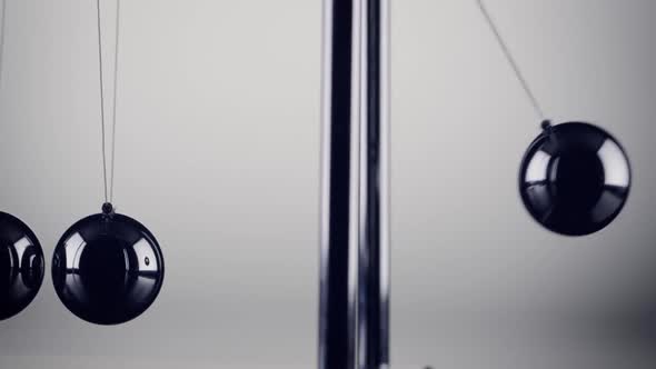 The balls of a Newtons Cradle colliding in slow motion alt