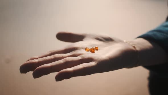 Shot of Three Tiny and Beautiful Amber Sitting on Top of a Woman's Palm