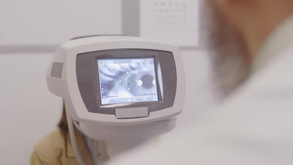 Optometrist Using Autorefractor during Eye Examination