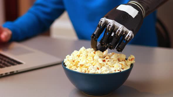 Young Man Watching a Movie in Laptop and Eating Pop Corn at Home