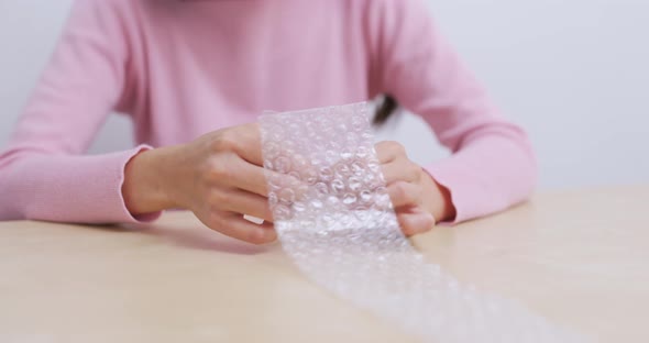 Woman play with bubble wrap to relief stress