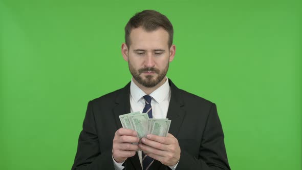 Ambitious Businessman Counting the Money Against Chroma Key